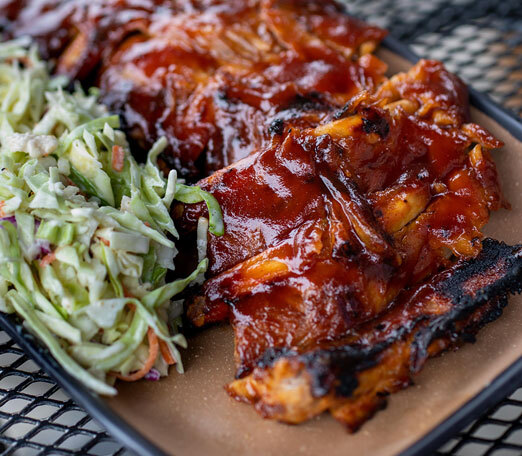 a plate of ribs and coleslaw